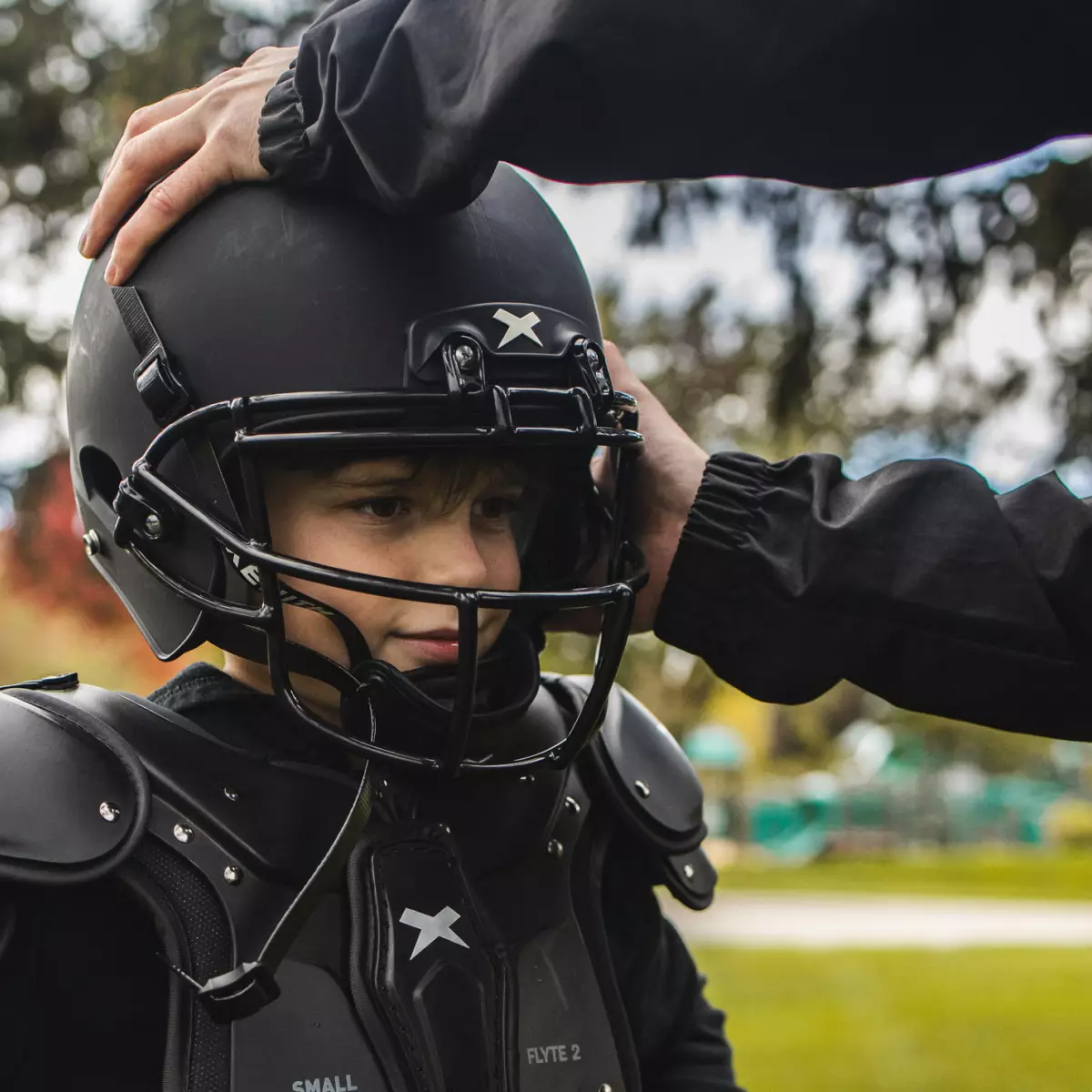 A youth athlete getting fitted for a Xenith helmet.